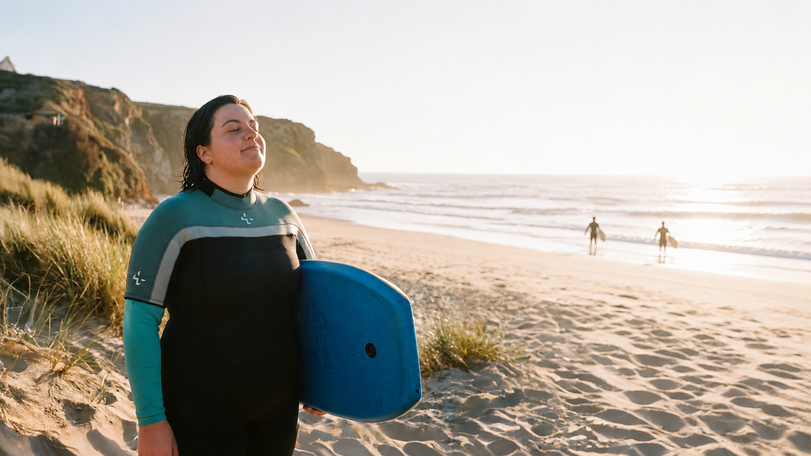 Surferin mit maßgefertigtem Wetsuit am Strand bei Sonnenuntergang